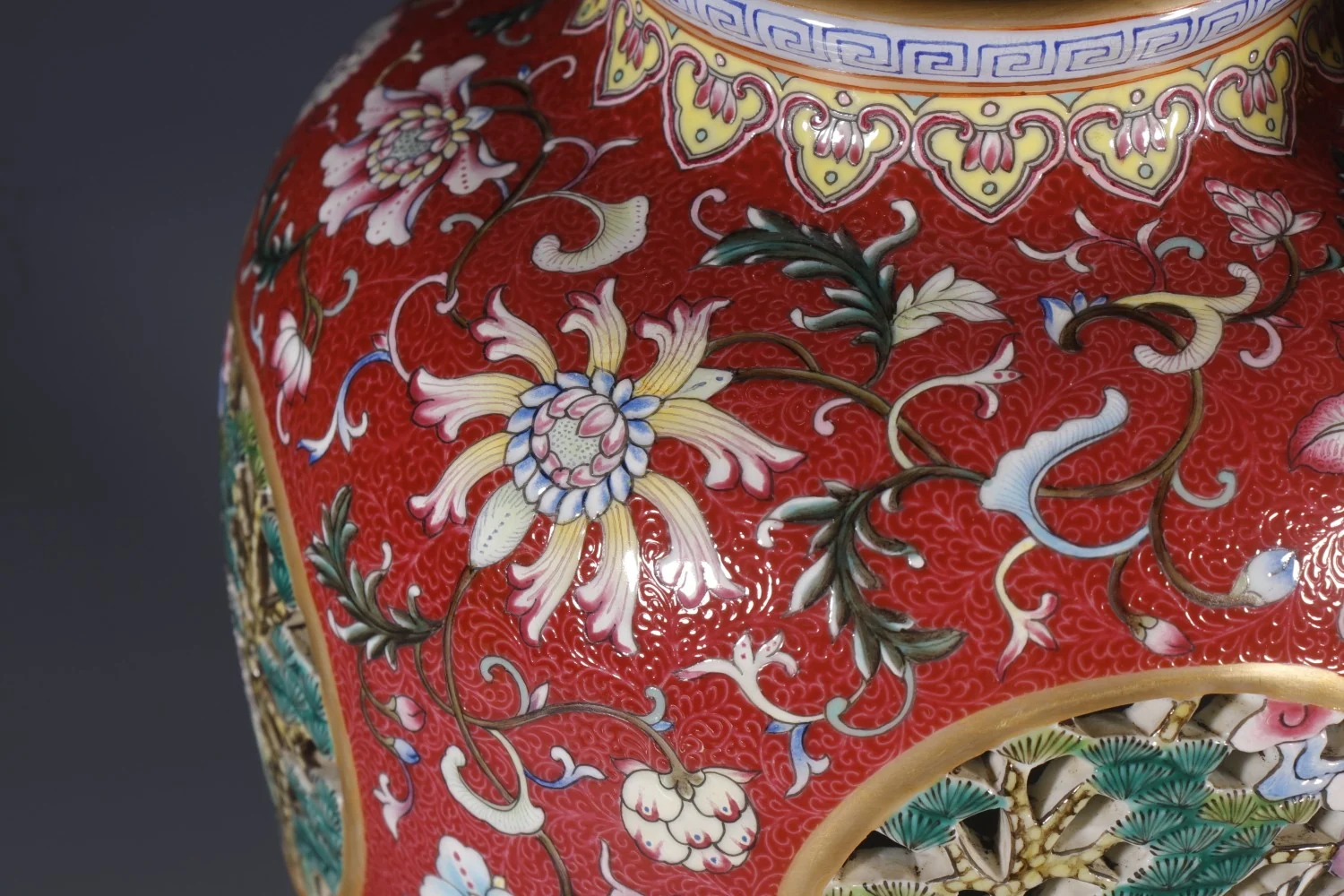 Iron-red ground with famille-rose floral scrolls and an openwork medallion