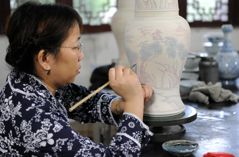 Jingdezhen artisan hand-painting a porcelain vase