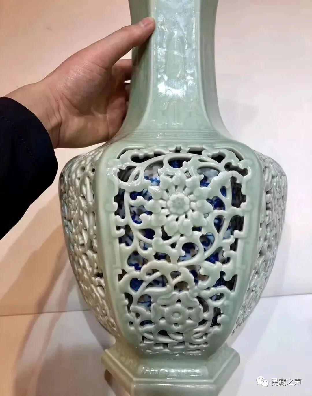 Hand-held view showing the pierced relief of a celadon openwork porcelain vase